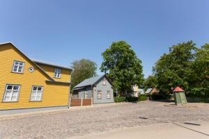 a yellow house on the side of a road at Silbernagel Apartment in Kuressaare
