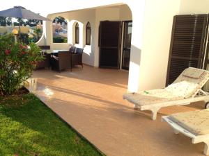 een patio met 2 ligstoelen en een parasol bij 3 bedrooms house at Carvoeiro 650 m away from the beach with shared pool furnished garden and wifi in Carvoeiro