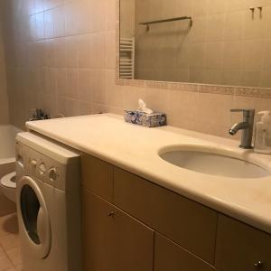 a bathroom with a sink and a washing machine at Apartment on the Beach with View in Rethymno