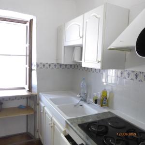 a kitchen with white cabinets and a sink at Malarias 1 in Rochemaure +22 photos