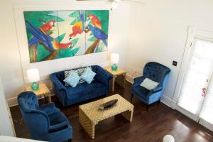 una sala de estar con 2 sillas azules y una pintura en Duval House en Key West