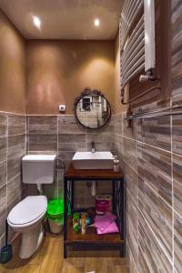 a bathroom with a toilet and a sink and a mirror at Natura Apartment in Belgrade