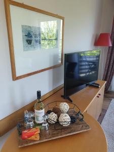 una mesa con una botella de vino y un televisor en Ferienwohnung Warnemünde - Landhaus Immenbarg, en Diedrichshagen