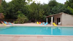 ラグラスにあるMaison de 4 chambres avec piscine partagee et wifi a Lagrasseのスイミングプール(椅子付)と家