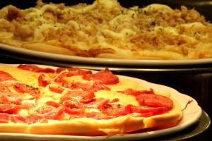 two plates of pizza sitting on a table at Royal Macaé Palace Hotel in Macaé