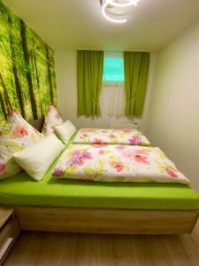 um quarto com uma cama verde com flores em Ferienwohnung Günter im Tonbachtal em Baiersbronn