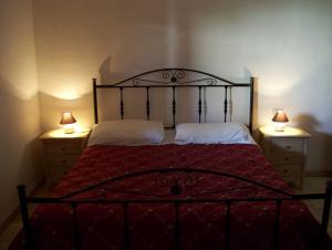 ein Schlafzimmer mit einem Bett mit zwei Lampen an zwei Kommoden in der Unterkunft Agriturismo Locanda Ventura in Fasano