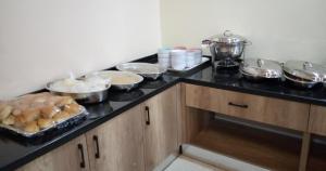 a kitchen counter with bowls and pans of food at Lit Suites in Abuja