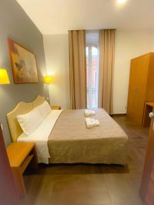 1 dormitorio con 1 cama con 2 toallas en Rome Travellers Hotel, en Roma