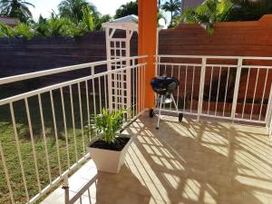 a porch with a white fence and a plant at ROY'AL BEACH HOLIDAYS in Sainte-Luce