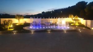 fontanna z oświetleniem w ogrodzie w nocy w obiekcie Villa Natia w mieście Mottola