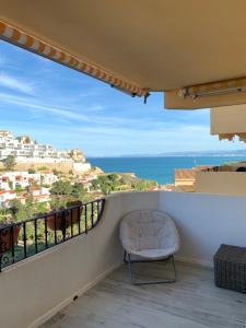 une chaise sur un balcon avec vue sur l'océan dans l'établissement Apartamento in Cullera. Spain, à Cullera