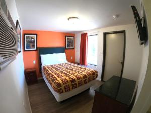 1 dormitorio con 1 cama con pared de color naranja en Rest Inn - Elizabeth en Elizabeth