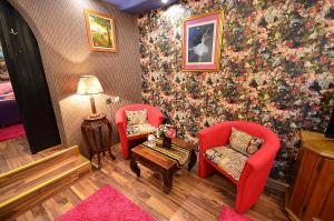 a living room with two red chairs and a table at Villa Miris Dunja in Zlatibor