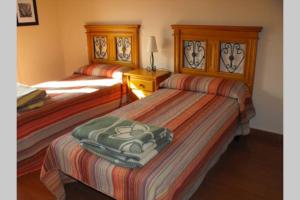two beds in a hotel room withskirts at CASA RURAL ALTA YUBERIA in Berlanga de Duero