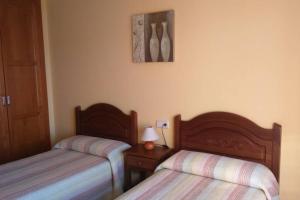 1 dormitorio con 2 camas y mesa con lámpara en CASA RURAL ALTA YUBERIA en Berlanga de Duero