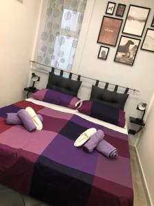 a bedroom with two beds with purple and purple pillows at Barce rooms in Palermo