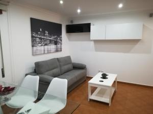 ein Wohnzimmer mit Sofa und Tisch in der Unterkunft Maré Beach in Monte Gordo
