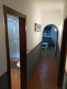 a hallway leading to a room with a bathroom at Maré Beach in Monte Gordo