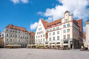 a group of buildings with umbrellas on a street at Dream Stay - Main Square Apartment with Picturesque View in Tallinn