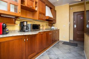 a kitchen with wooden cabinets and a microwave at Dream Stay - Main Square Apartment with Picturesque View in Tallinn