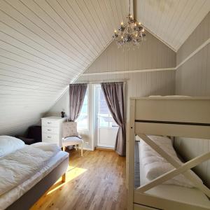 a attic bedroom with two bunk beds and a chandelier at Lysefjorden - Gøysa Gard in Forsand +43 photos