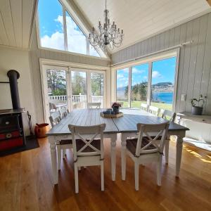 a dining room with a table and chairs and windows at Lysefjorden - Gøysa Gard in Forsand