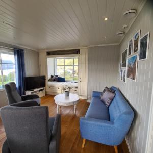 a living room with a blue couch and chairs at Lysefjorden - Gøysa Gard in Forsand