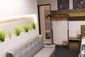 un soggiorno con divano e piante sul muro di Apartmány Caffe & Grill a Roudnice nad Labem