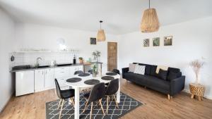 kuchnia i salon ze stołem i krzesłami w obiekcie Apartament Latarnika w mieście Jarosławiec