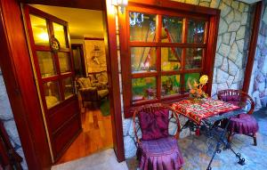 a table with purple chairs in a room with a door at Villa Miris Dunja in Zlatibor