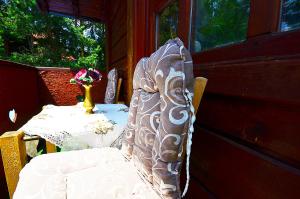 a chair with a table and a vase with flowers at Villa Miris Dunja in Zlatibor