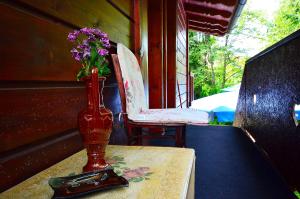 a vase on a table with a chair and a vase with flowers at Villa Miris Dunja in Zlatibor