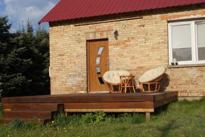 a house with two chairs and a wooden deck at Siedlisko Podlasie in Kuraszewo