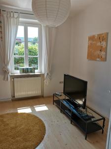 a living room with a flat screen tv and a large window at Ferienhaus Lenz in Pünderich