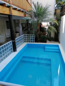 a swimming pool in the backyard of a house with a blue swimming pool at Don Giovanni Mancora in Máncora