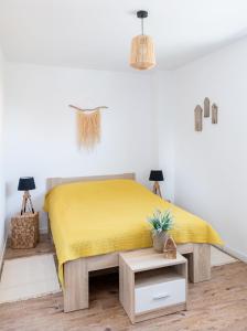 a bedroom with a bed with a yellow bedspread at Apartament Latarnika in Jarosławiec