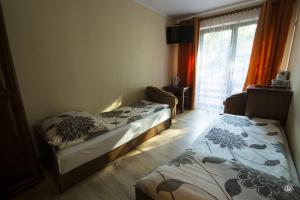 Dos camas en una habitación con ventana. en Siedlisko Na Fali, en Krynica Morska