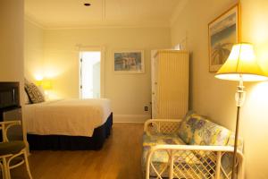 une chambre d'hôtel avec un lit, un canapé et une lampe dans l'établissement Duval House, à Key West