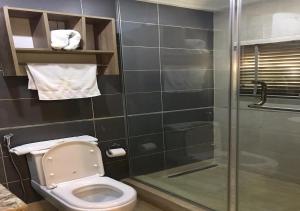a bathroom with a toilet and a glass shower at Lit Suites in Abuja