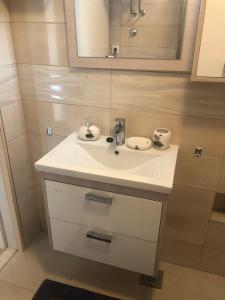 a bathroom with a white sink and a mirror at Apartman Mara in Hvar