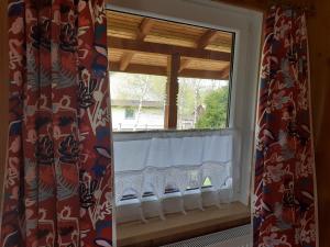 a window with curtains and a bench in a room at Siedlisko Bieszczadzkie 3 in Lutowiska