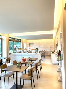 a restaurant with tables and chairs and a kitchen at Hotel Etruria in Forte dei Marmi