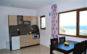a kitchen with a dining table and a kitchen with a window at Family Hotel Amore in Byala