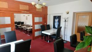 Hotel Antler في Studénka: غرفة طعام مع طاولة وكراسي