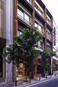 two trees in front of a building at Hotel Achilleas in Athens