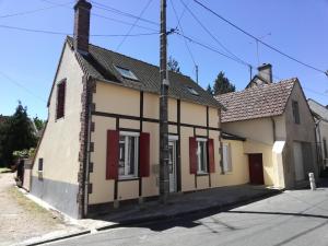una casa vieja con persianas rojas en una calle en Le Loft Montargis Gien maison de ville, en Sainte-Geneviève-des-Bois
