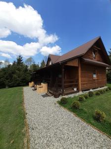a log cabin with a gravel path in front of it at Siedlisko Bieszczadzkie 1 in Lutowiska