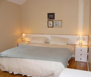 Windsor Lodge B&B في دون لاوجير: غرفة نوم بسرير كبير مع مواقف ليلتين