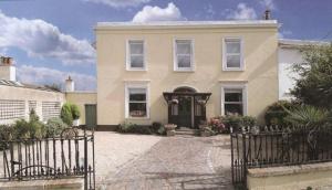una casa blanca con una puerta delante de ella en Windsor Lodge B&B en Dun Laoghaire